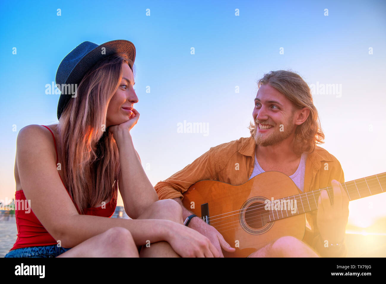 Glückliche Gruppe von Freund in Partei und Gitarre spielen am Strand Stockfoto