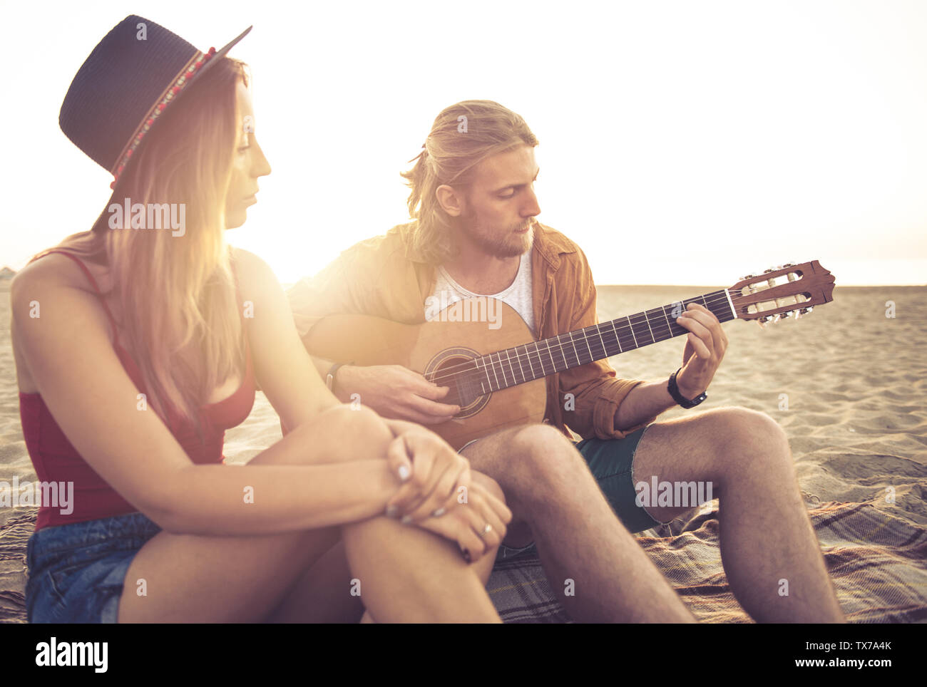 Glückliche Gruppe von Freund in Partei und Gitarre spielen am Strand Stockfoto