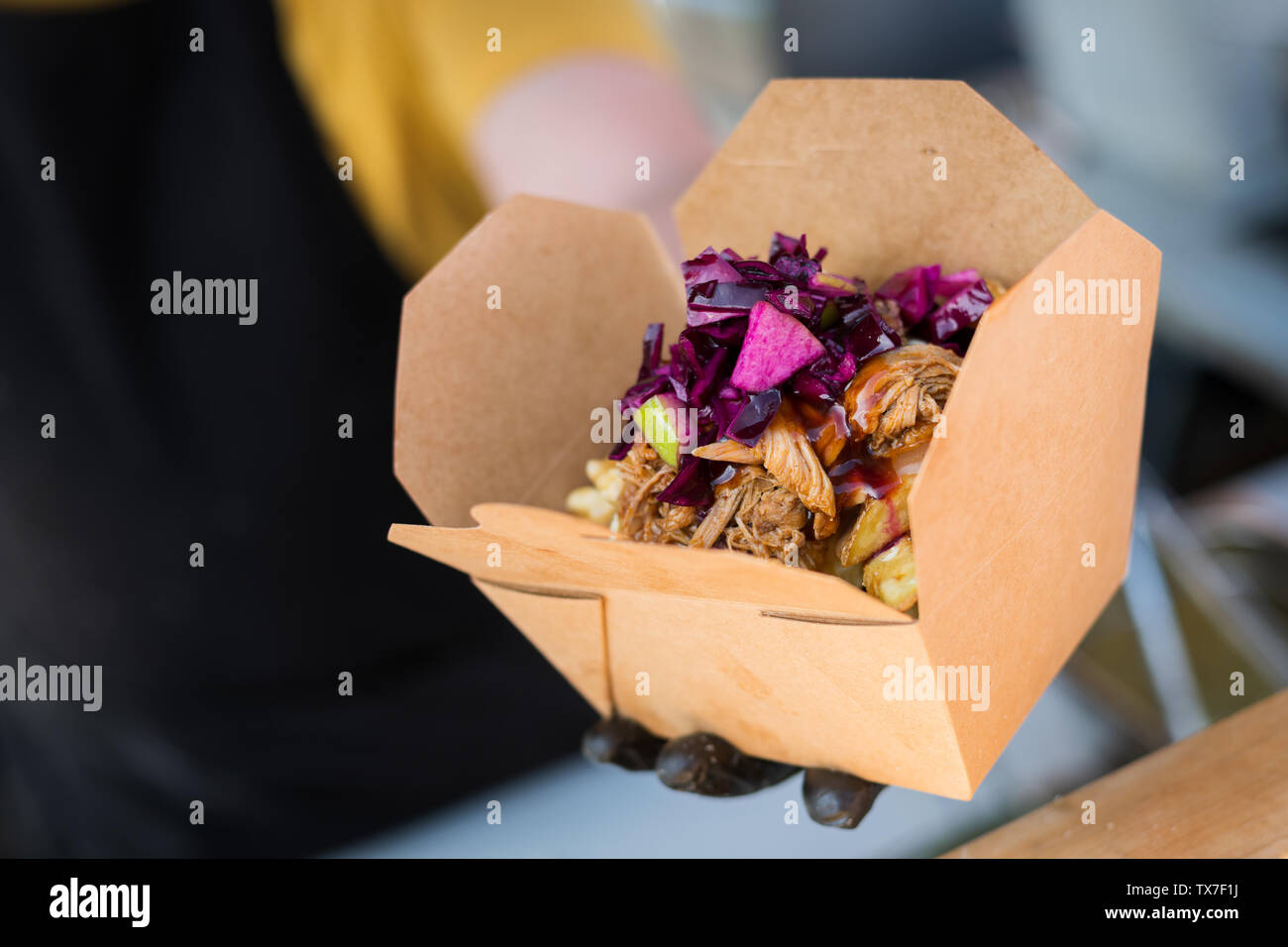Mann mit einem Huhn kebab mit Chips in einer Box zu einem Street Food Festival Stockfoto