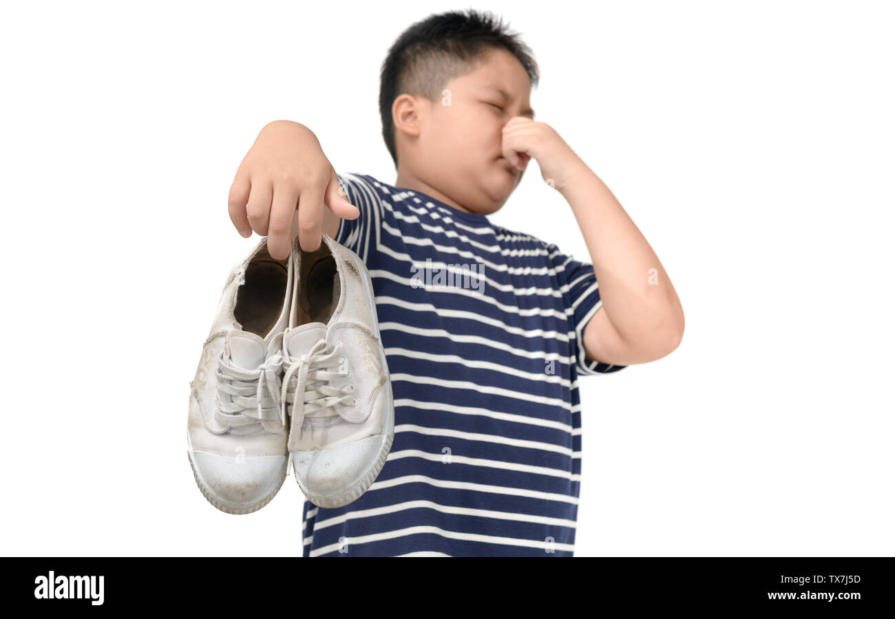 Fat Boy Holding ein Paar muffig und stinkig Schuhe auf weißem Hintergrund  angewidert Stockfotografie - Alamy