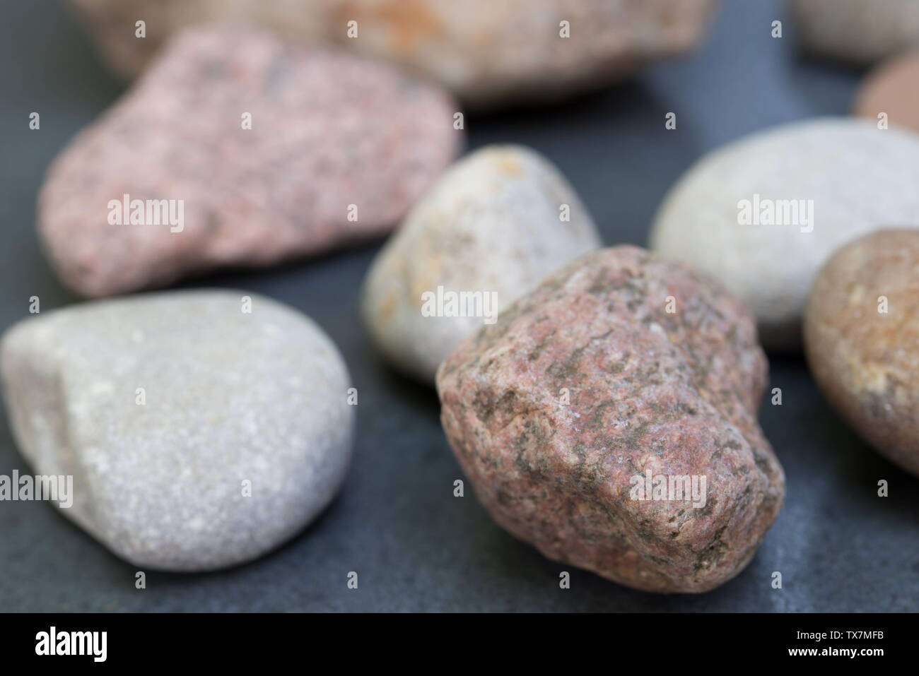 Stücke von Granit Stein auf grauem Hintergrund Stockfoto