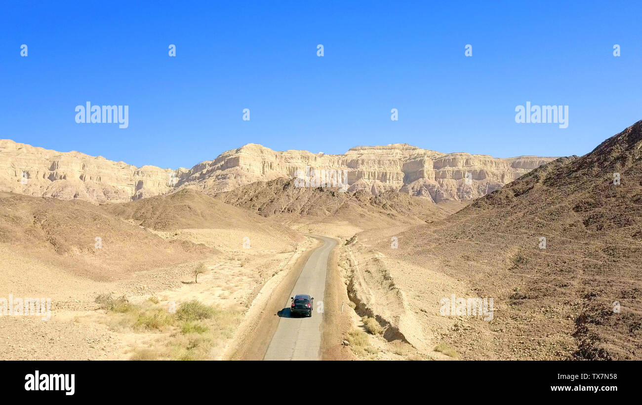 Einziges Auto auf einem alten Wüste Straße, Antenne folgen Bild. Stockfoto