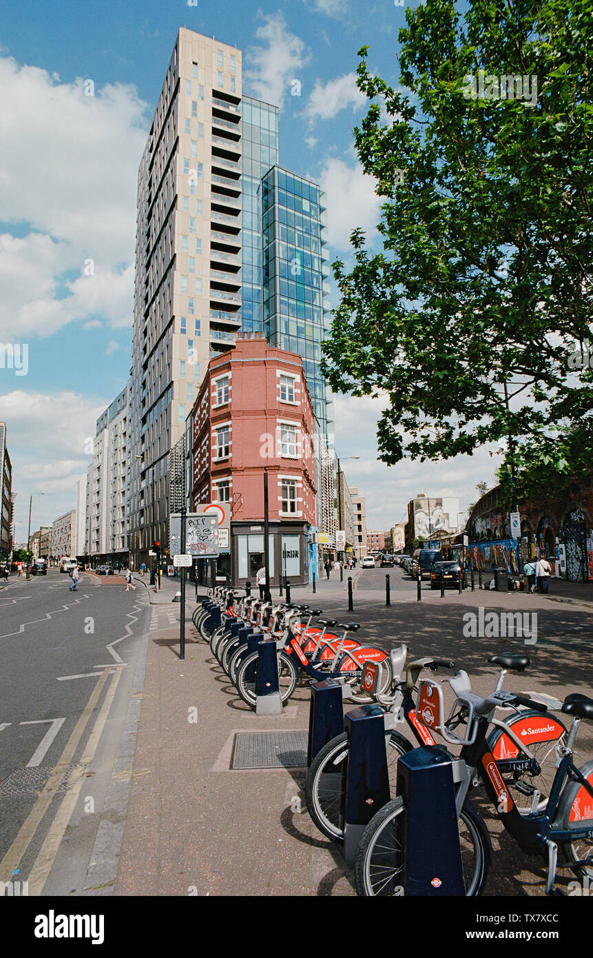 Bethnal Green Road an der Kreuzung mit der Sclater Straße, im East End von London, mit neuen Wohnanlagen Stockfoto