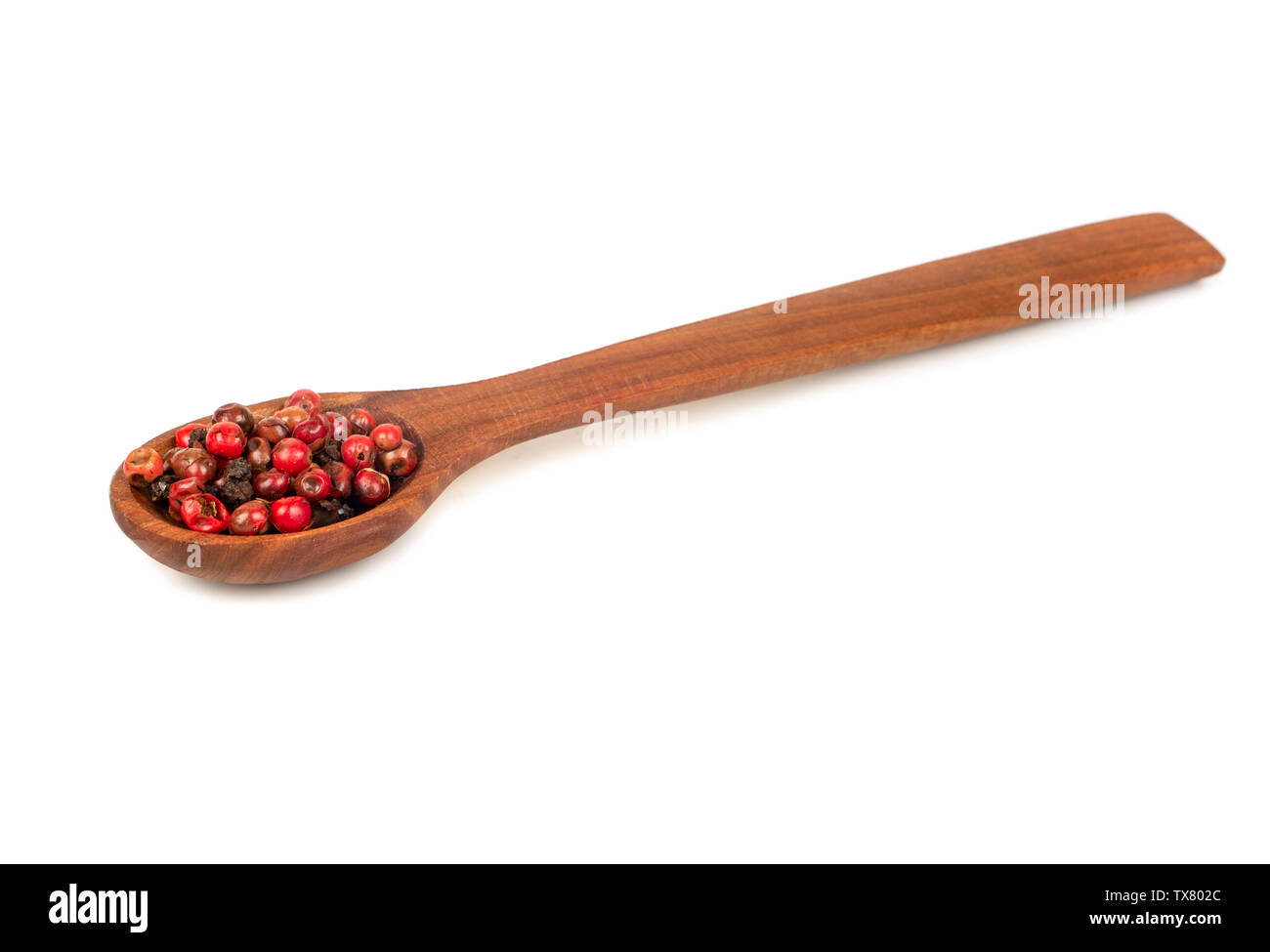 Trocken rote Paprika Erbsen in hölzernen Löffel auf weißem Hintergrund Stockfoto