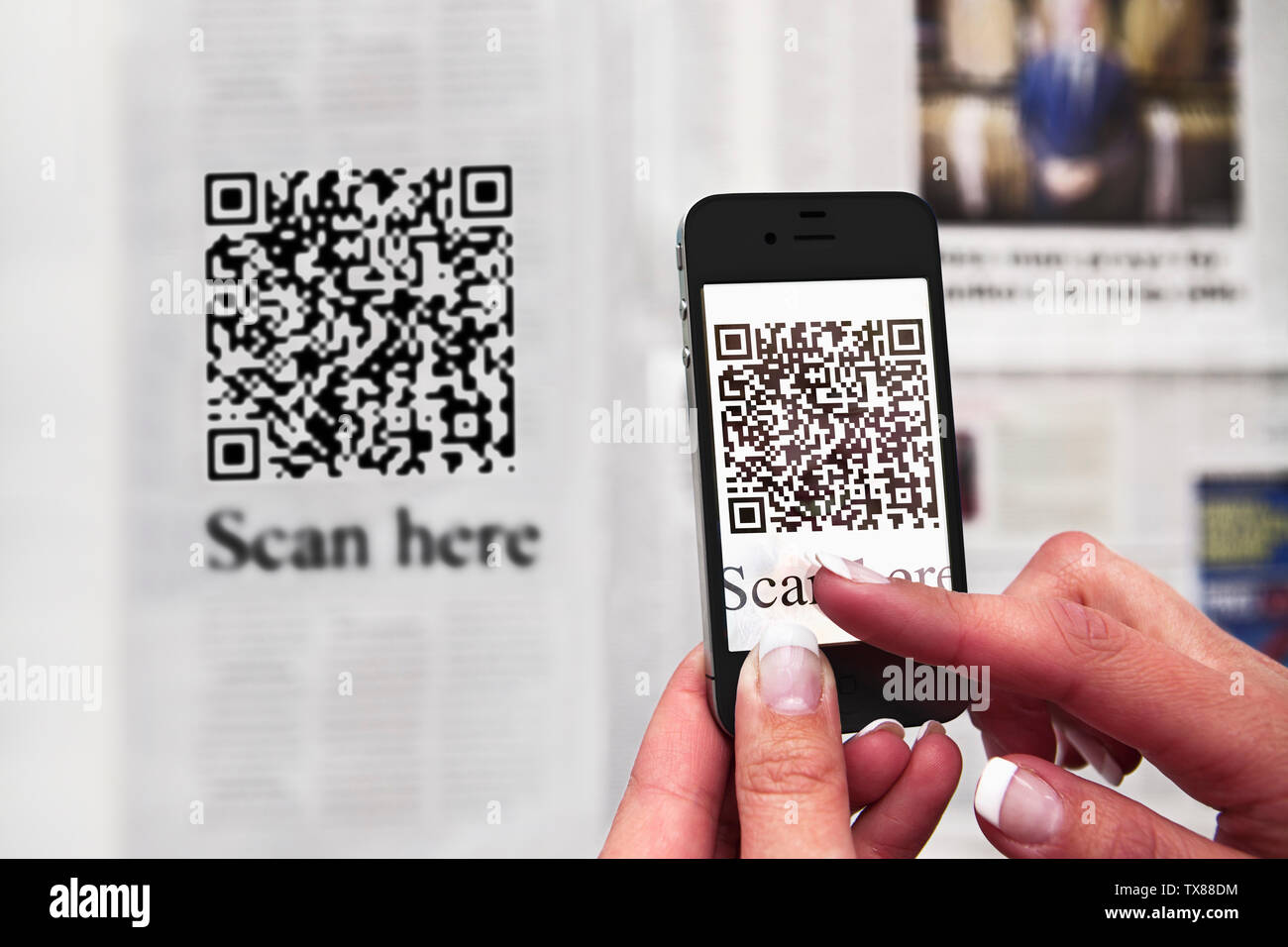 Eine Frau, die das Scannen eines QR-Code mit einem smart phone Stockfoto