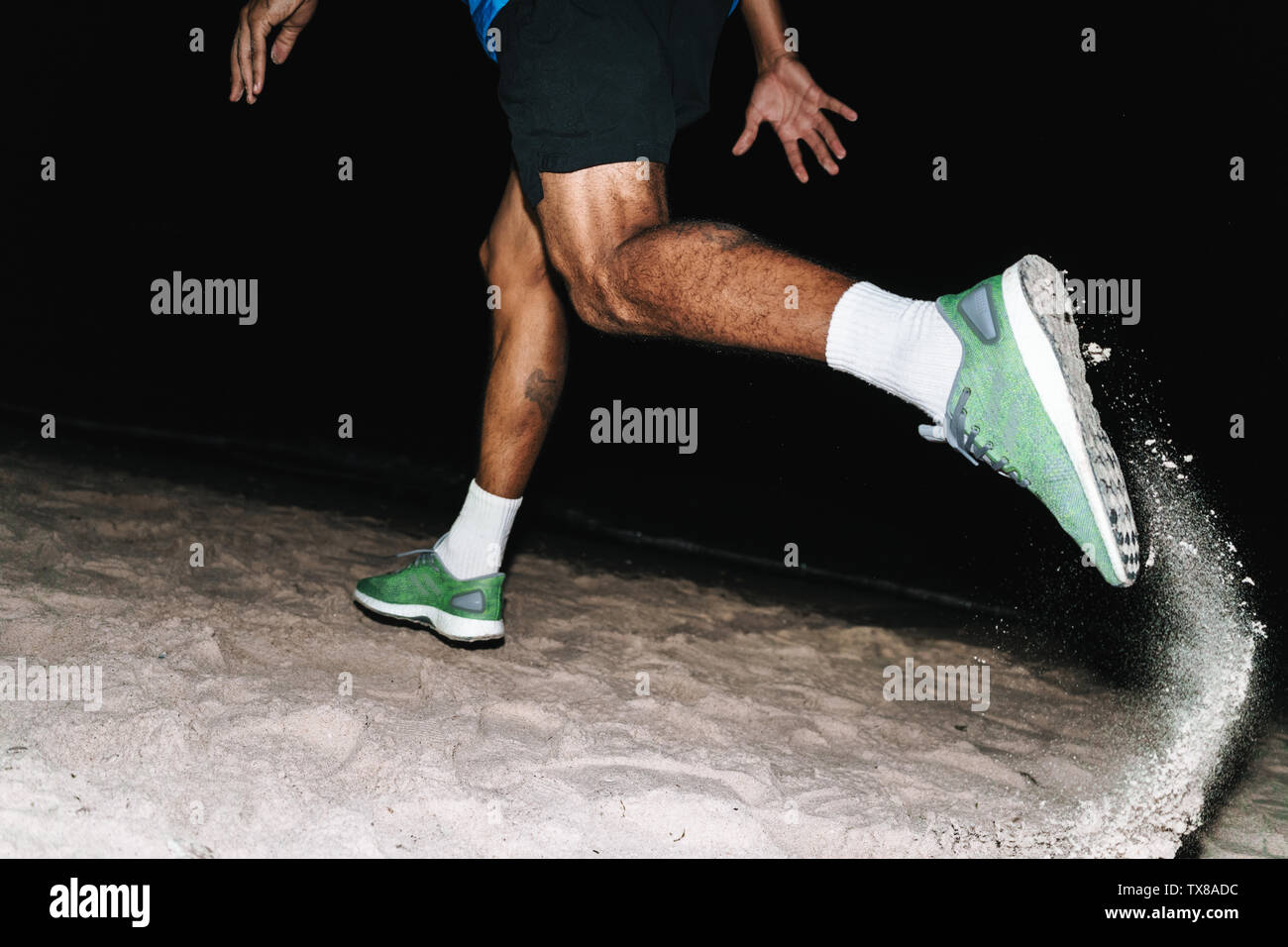 Die Hälfte portrait Seitenansicht einer afrikanischen Sportler laufen am Strand bei Nacht Stockfoto