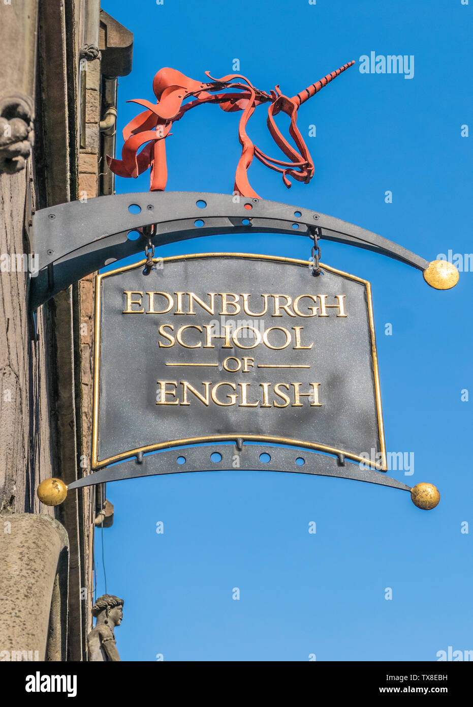 Reich verzierten Schild außerhalb der Edinburgh School of English, auf Canongate, die Royal Mile, gegen ein strahlend blauer Himmel. Schottland, Großbritannien. Stockfoto