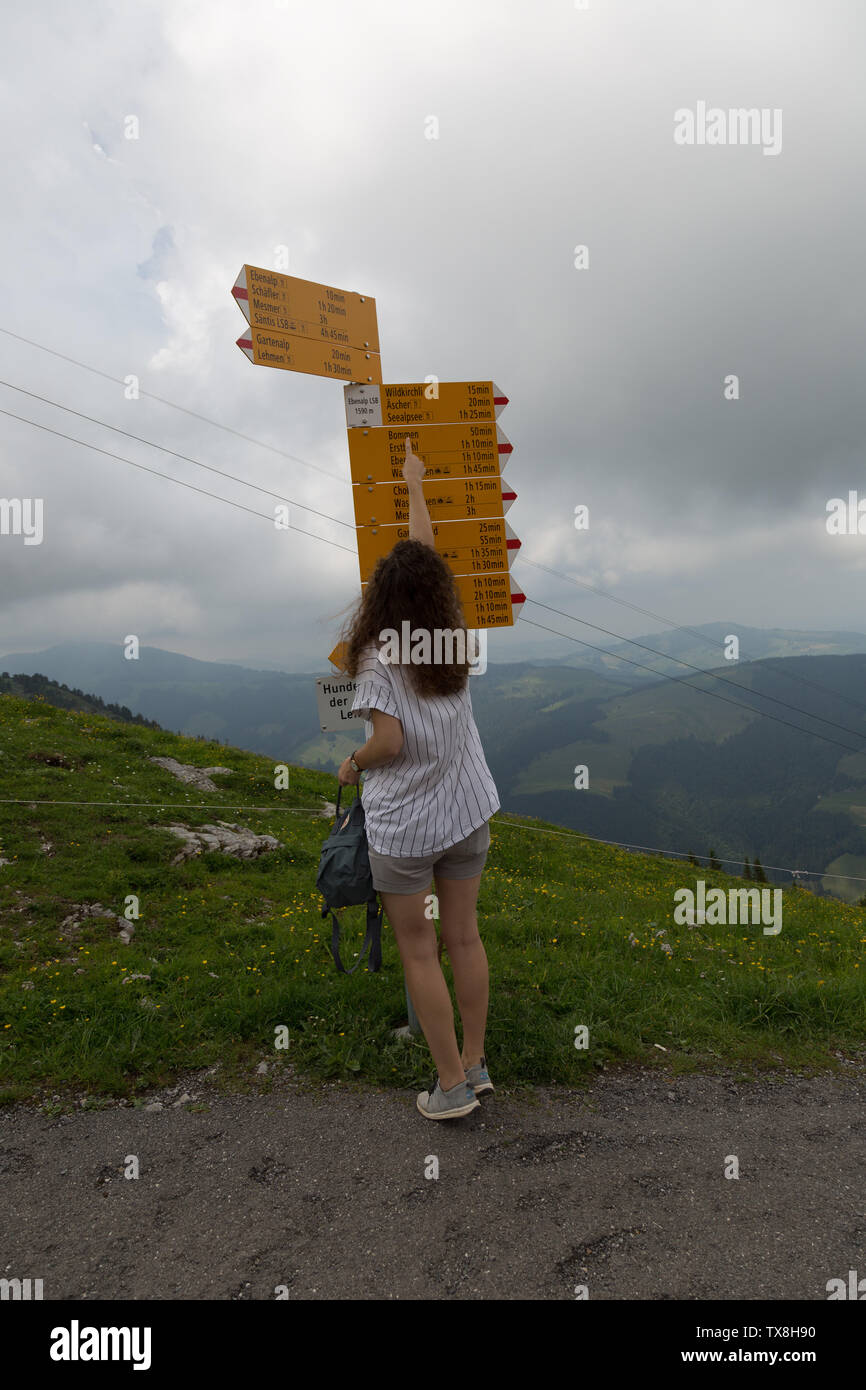 Ein verlorener Tourist weist auf ihr Wunschziel auf der Ebenalp in den Schweizer Alpen. Stockfoto