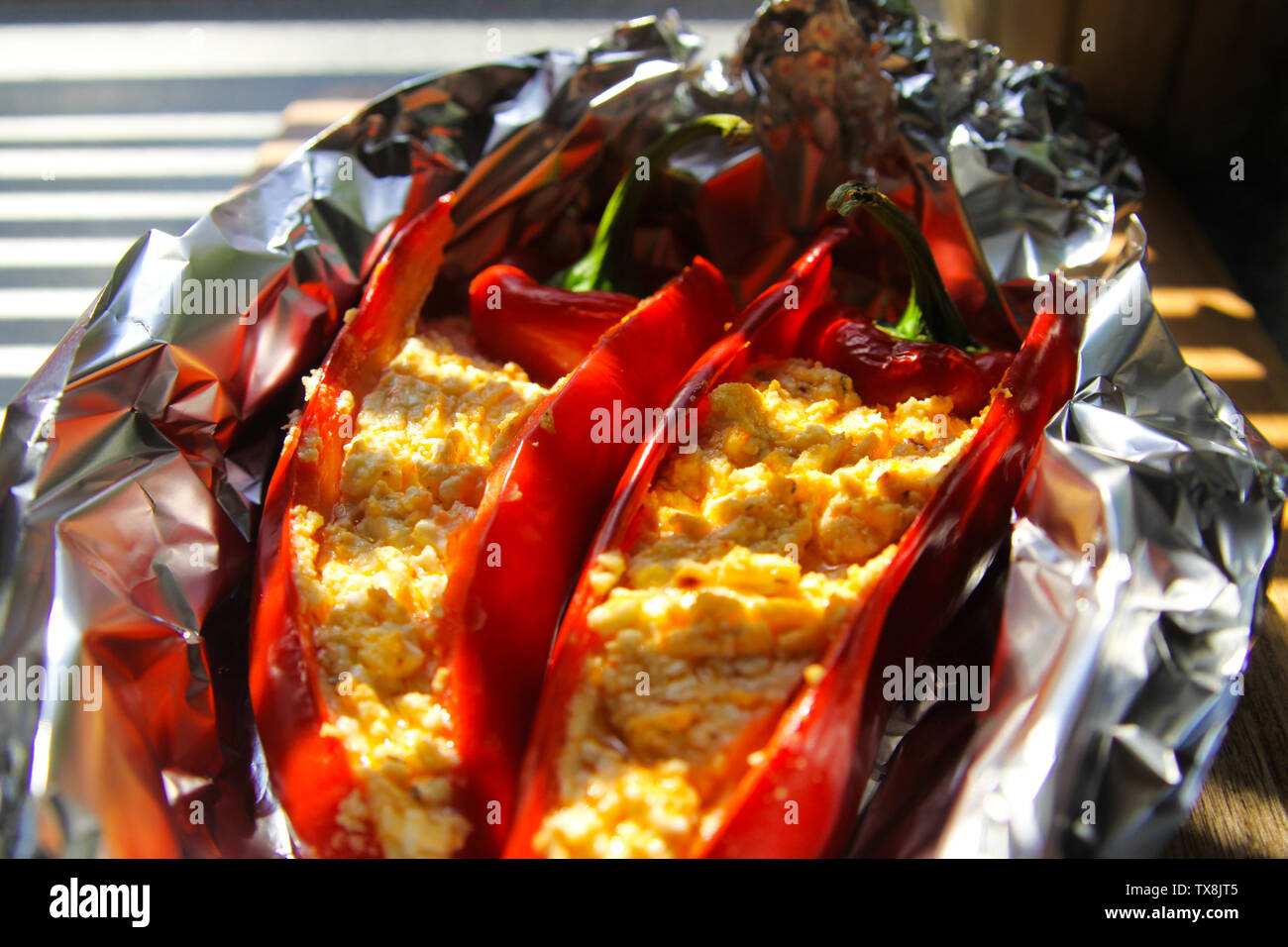 Nahaufnahme von gefüllte rote Paprika Paprika mit Schaf Feta Käse gewürzt mit pikanten Chili in Alufolie gegrillt Stockfoto