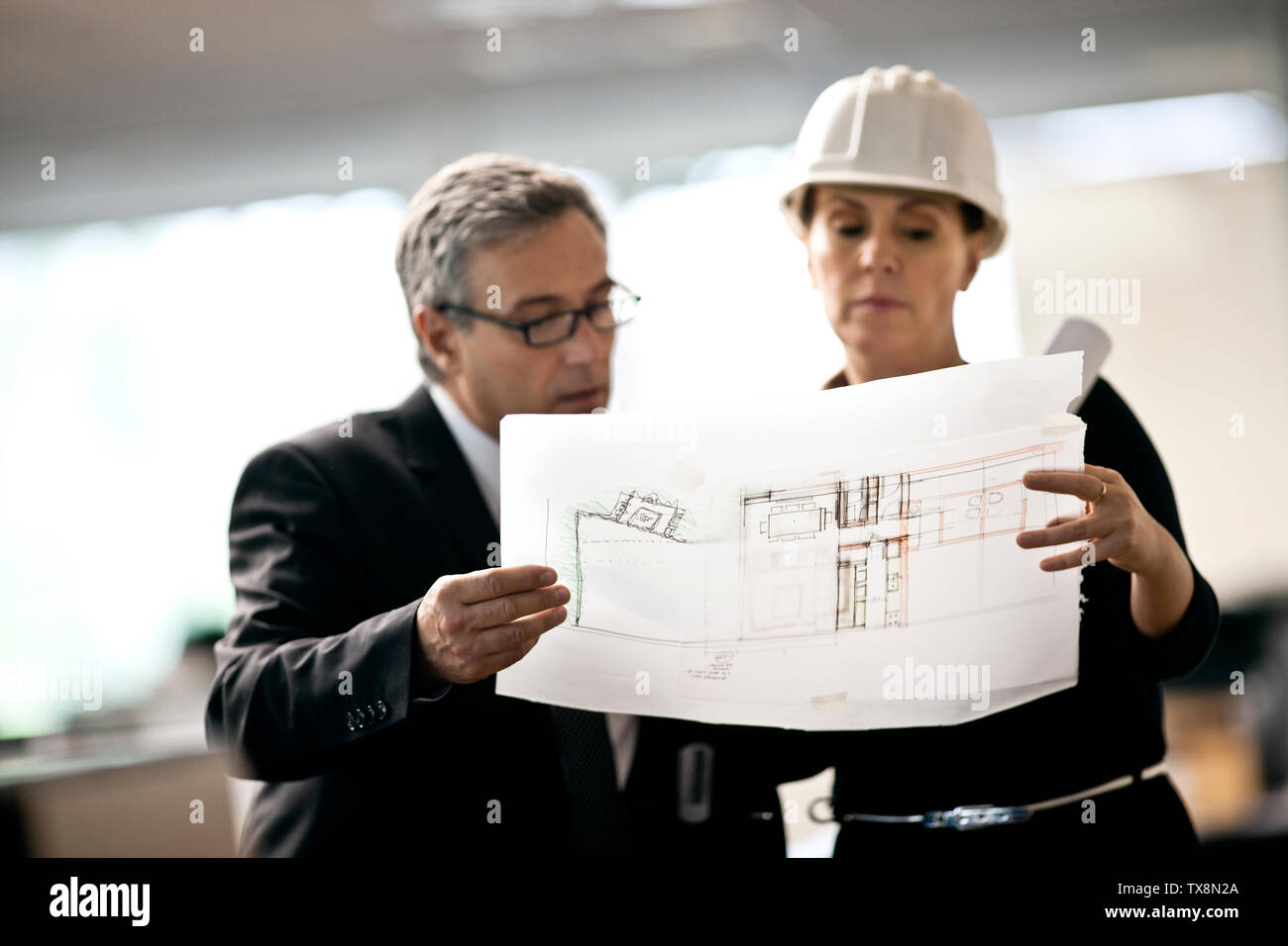 Architekt in hardhat diskutieren Blueprints mit Kunde. Stockfoto