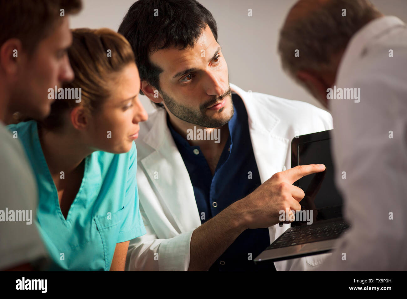 Gruppe von Ärzten etwas diskutieren auf einem Laptop. Stockfoto