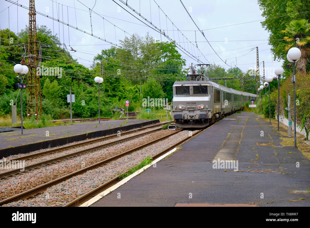 Französische Intercity in die Pau entfernt. Ansicht der Plattform neben Titel und elektrische Leitungen. Pau, Frankreich, 8. Juni 2019 Stockfoto
