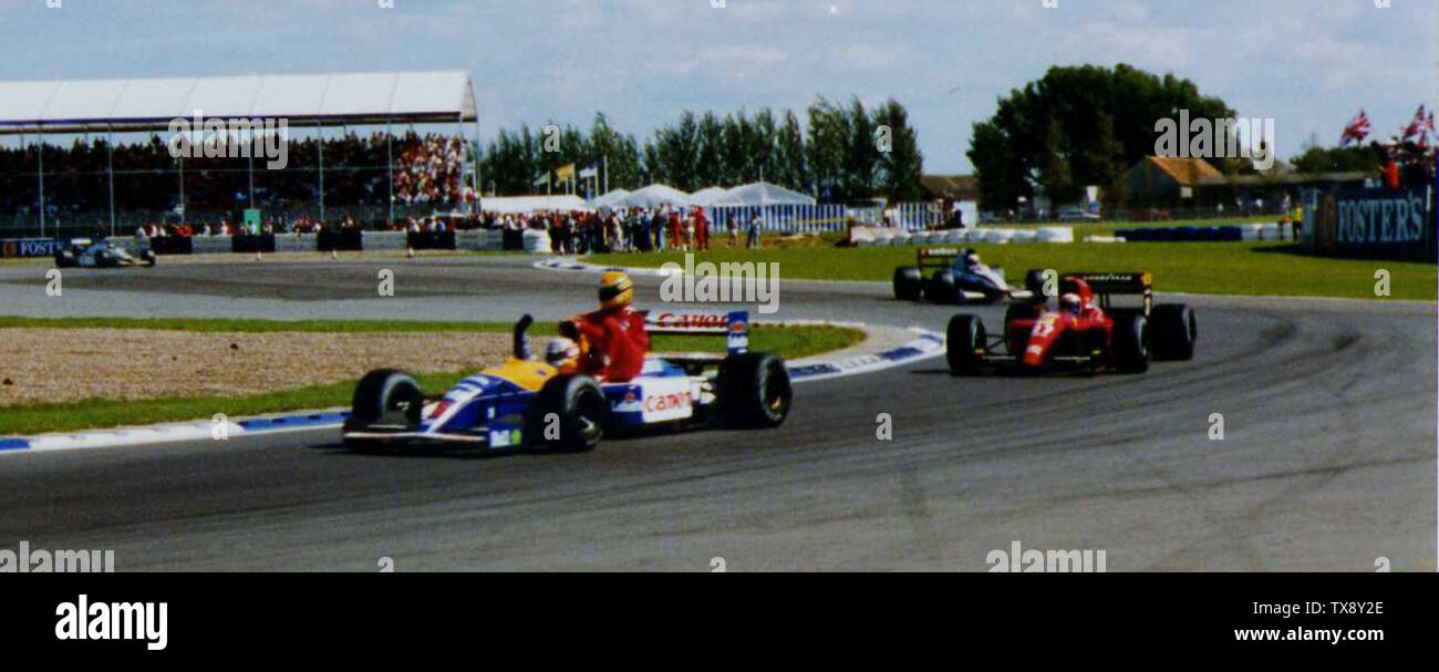 Nigel Mansell gibt Ayrton Senna einen Lift zurück zu den Gruben an der Seitenlage seines Williams FW14, nachdem Sennas eigener McLaren MP4/6 in der letzten Runde aus Treibstoff lief. Alain Prosts Ferrari F1-91 und ein Tyrrell 020 folgen.; Aufgenommen am 14. Juli 1991 onÂ; Bild:Mansell und Senna auf Silverstone.jpg; Stavros1; Stockfoto