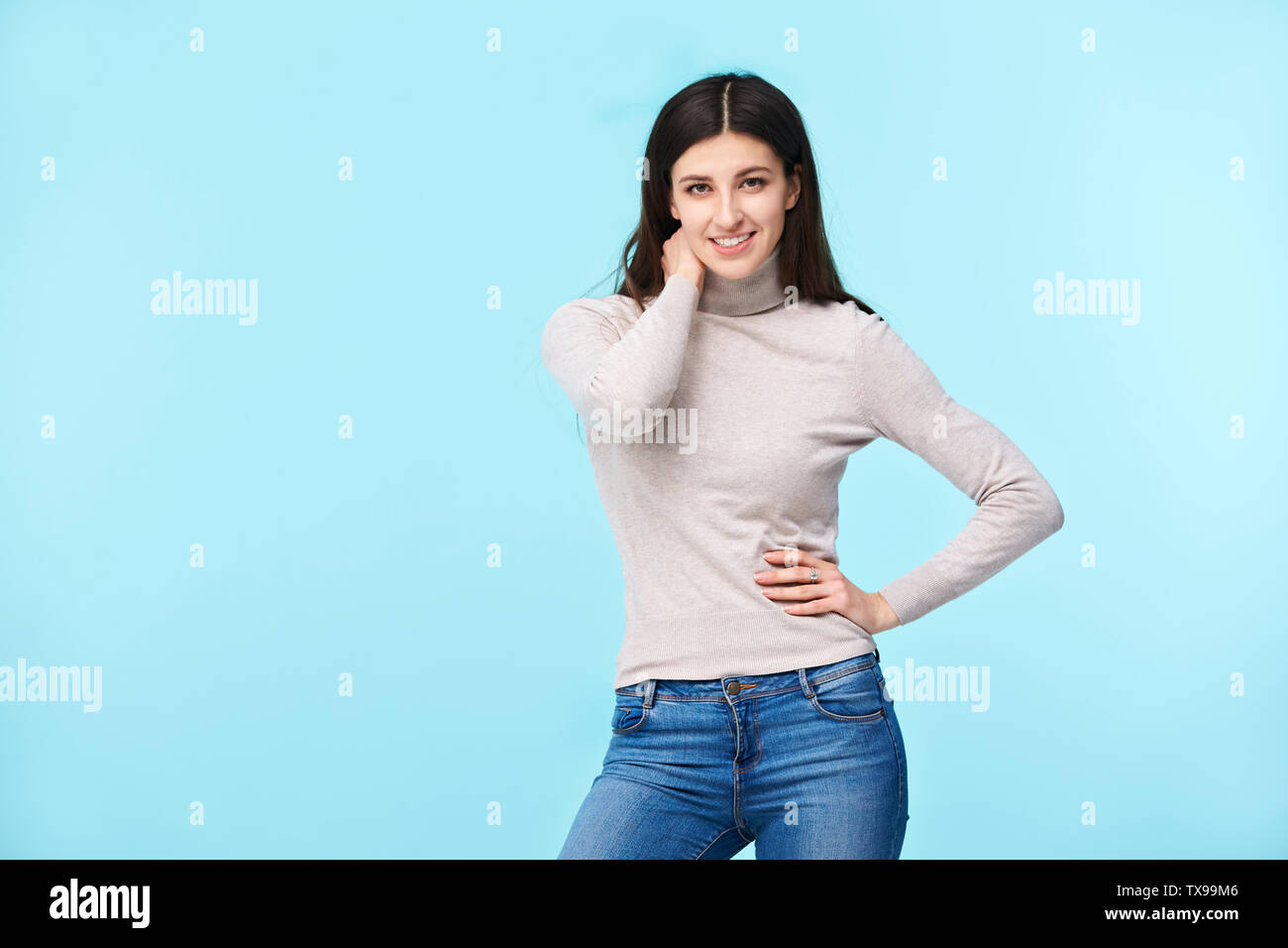 Studio Porträt einer wunderschönen kaukasische Frau, in die Kamera lächeln suchen, auf blauem Hintergrund isoliert Stockfoto