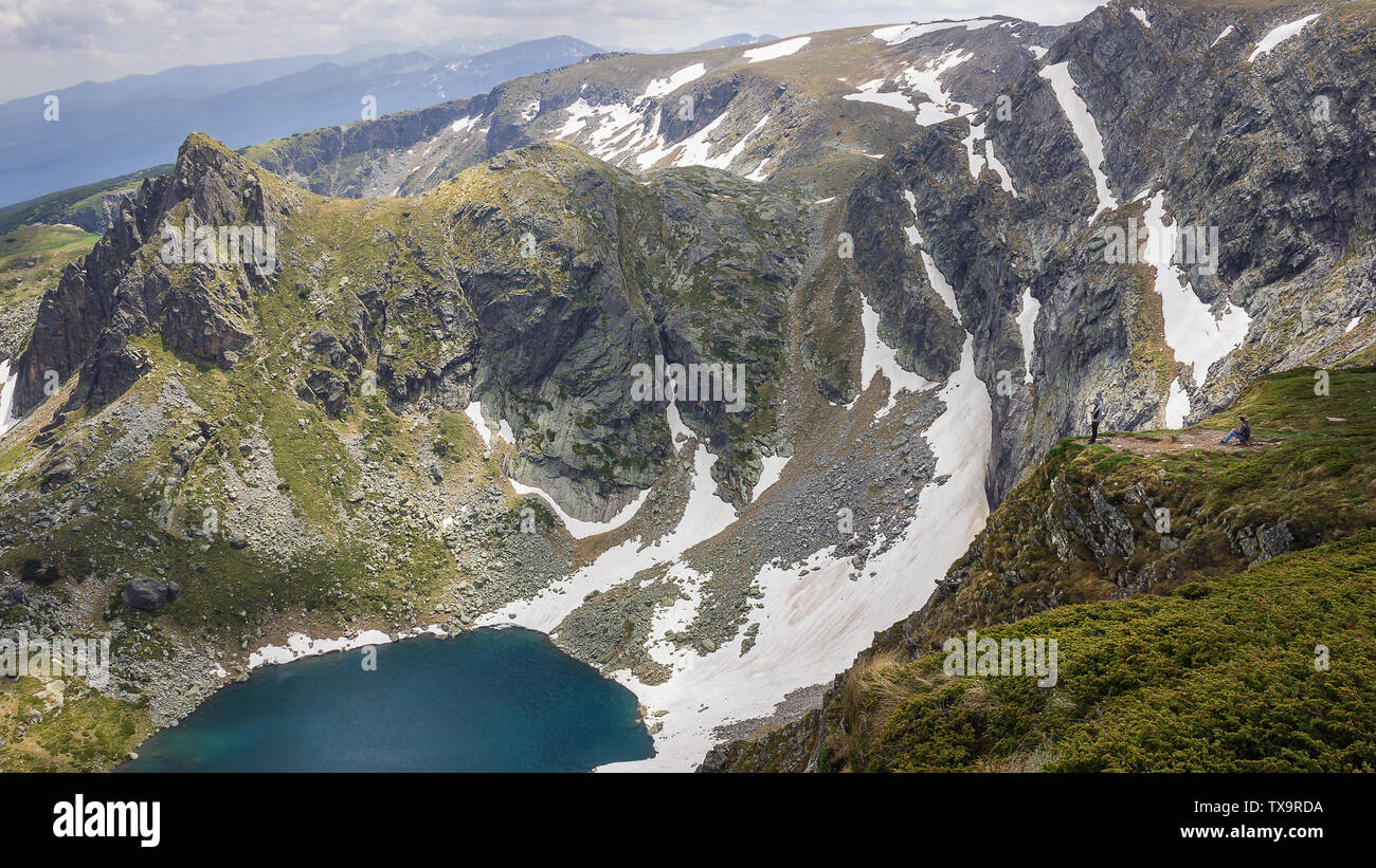 Zwei Bergwanderer genießt die Aussicht von einem Felsen in Zwillinge See und erstaunliche alien Landschaft von Rila Gebirge Stockfoto