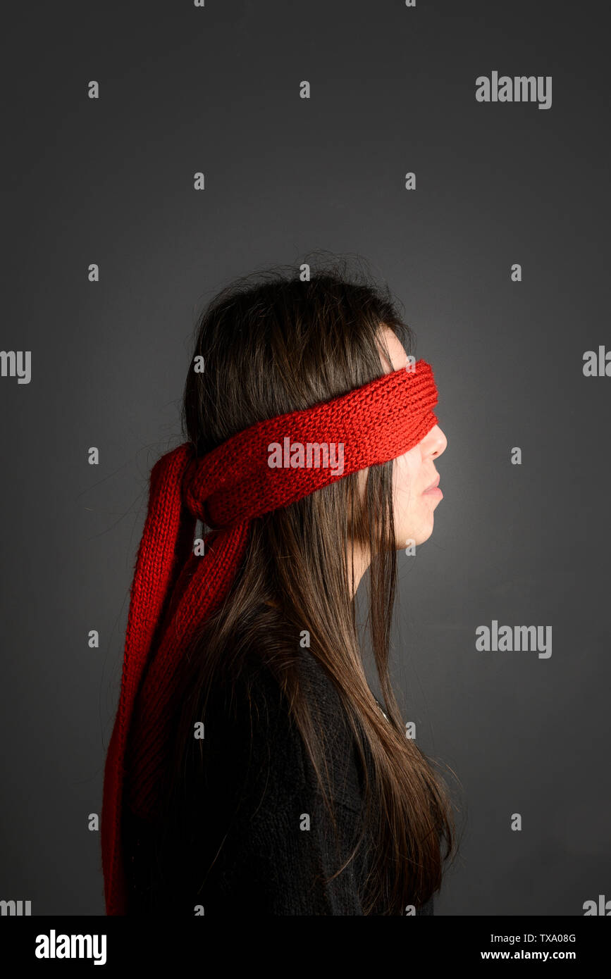 Junges Mädchen mit langen dunklen Haare mit verbundenen Augen mit roten Schal-sode vie Stockfoto