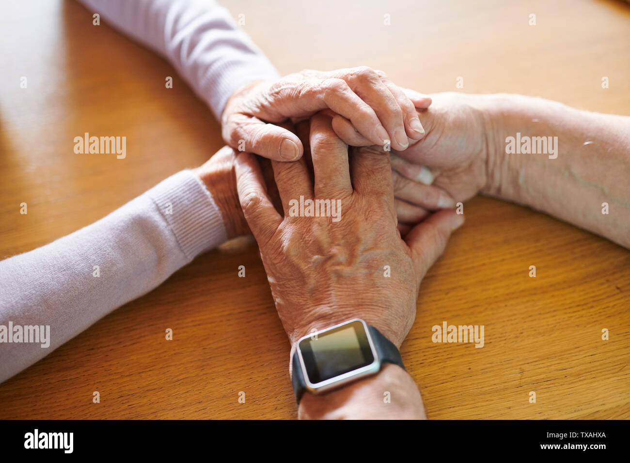 Hände zärtlich älterer Mann und Frau auf hölzernen Tisch Stockfoto