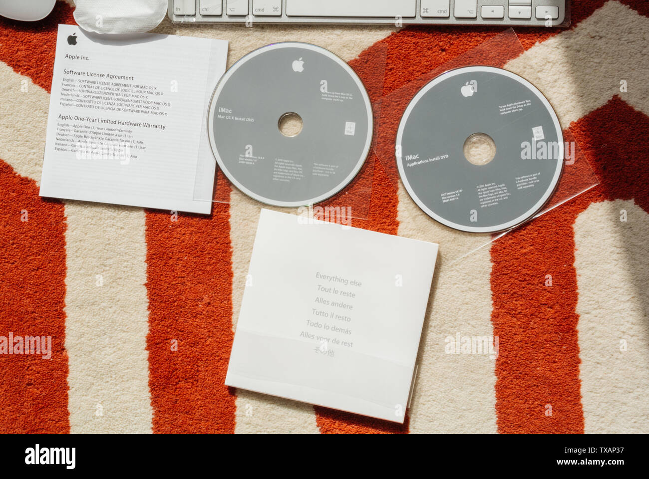 London, Großbritannien, 31. März 2014: Teile und Komponenten des neuen iMac 21,5 Personal Computer von Apple Computern beim Auspacken die Lizenzvereinbarung für die Software und dvd Software installieren MacOS X DVD-Datenträger Stockfoto