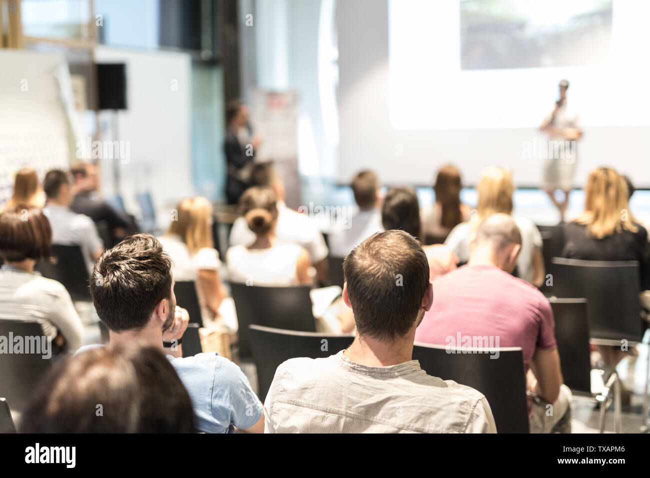 Unternehmer im Publikum stehen und Fragen stellen bei Business Konferenz zu speeker. Stockfoto