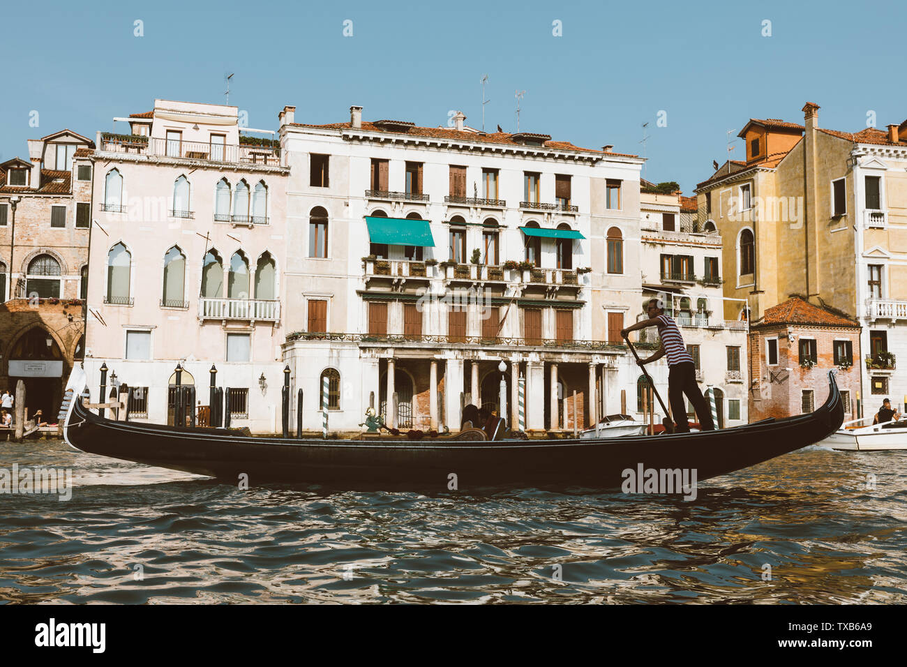 Venedig, Italien - Juli 2, 2018: Closeup Fotografie der Gondel mit Menschen und Gondoliere, im Hintergrund der historischen Gebäude des Grand Canal (Kann Stockfoto