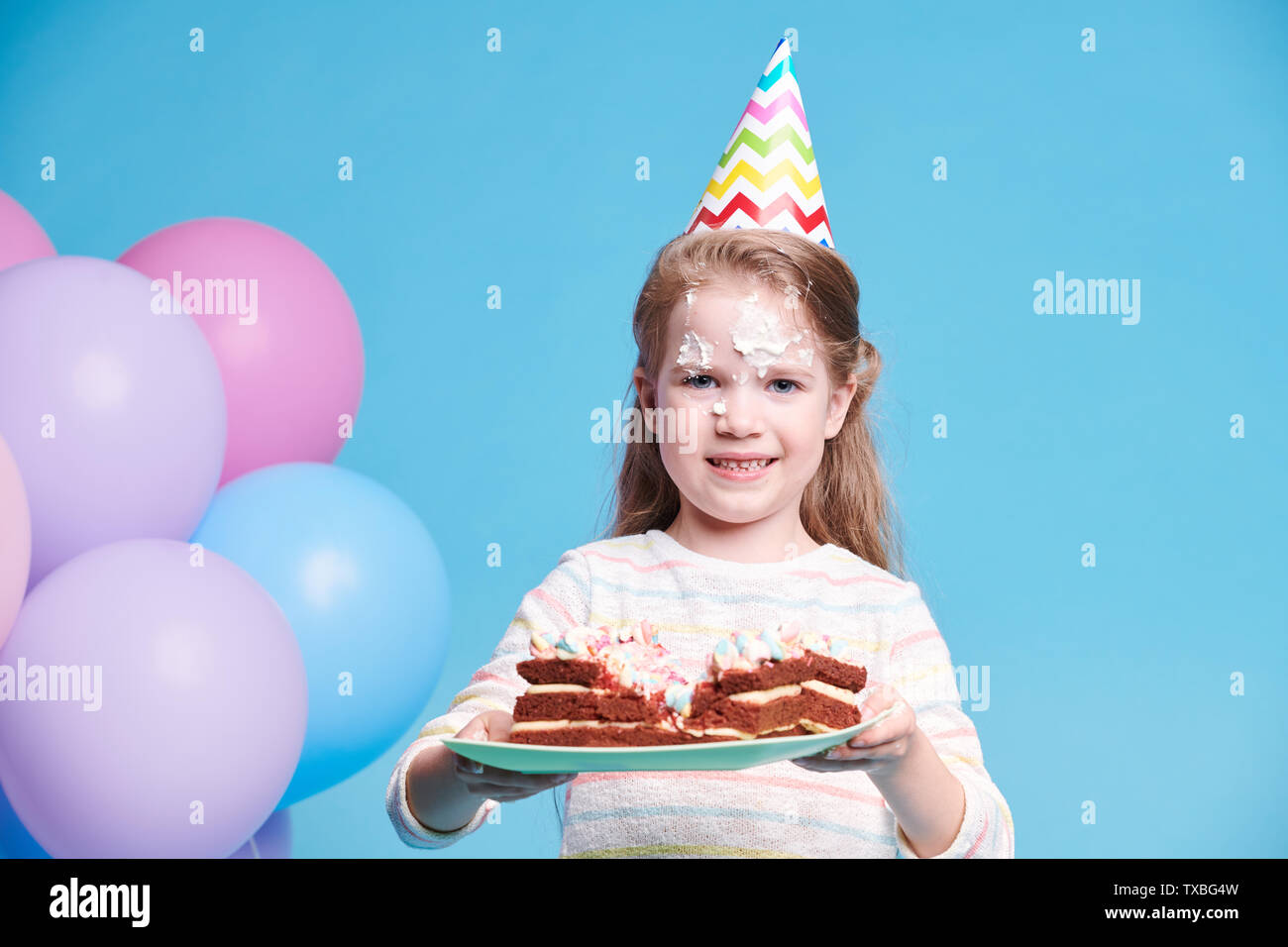 Gerne kleine Mädchen mit leckeren hausgemachten Kuchen auf dem Teller Stockfoto