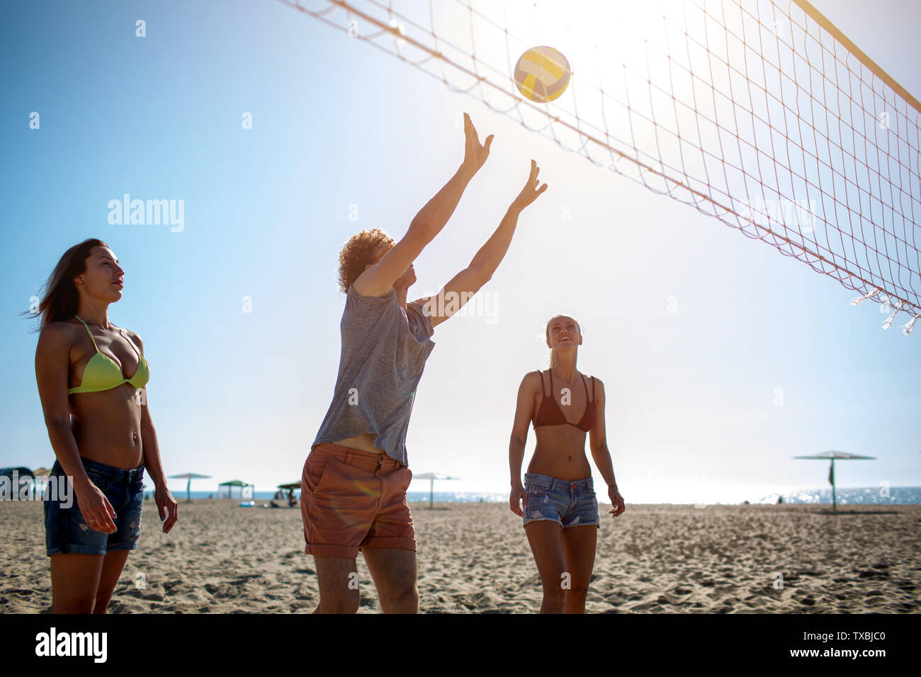 Gruppe von Freunden zu Beach-Volleyball am Strand spielen Stockfoto