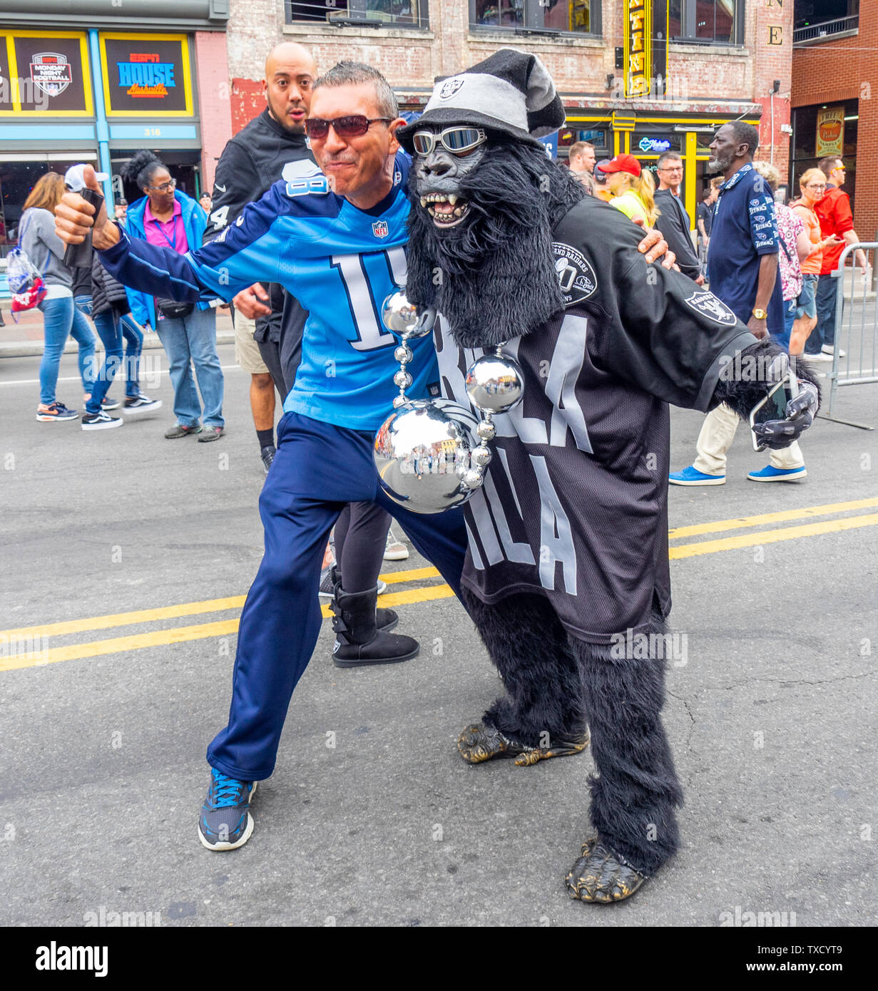 Tennessee Titans Fan und Fan der Oakland Raiders in Gorilla Kostüm posieren für Fotos am Broadway an NFL Draft 2019 Nashville Tennessee USA. Stockfoto