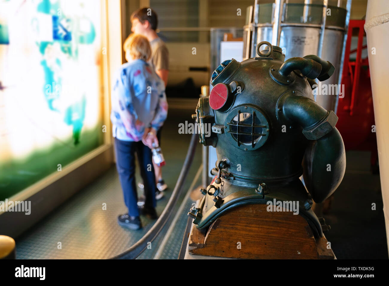 U-Boot Museum, Groton CT USA, Juni 2019. Großmutter und Enkel, der eine Karte des Krieges Taktik unter einer fokussierten Tiefseetauchen Helm. Stockfoto