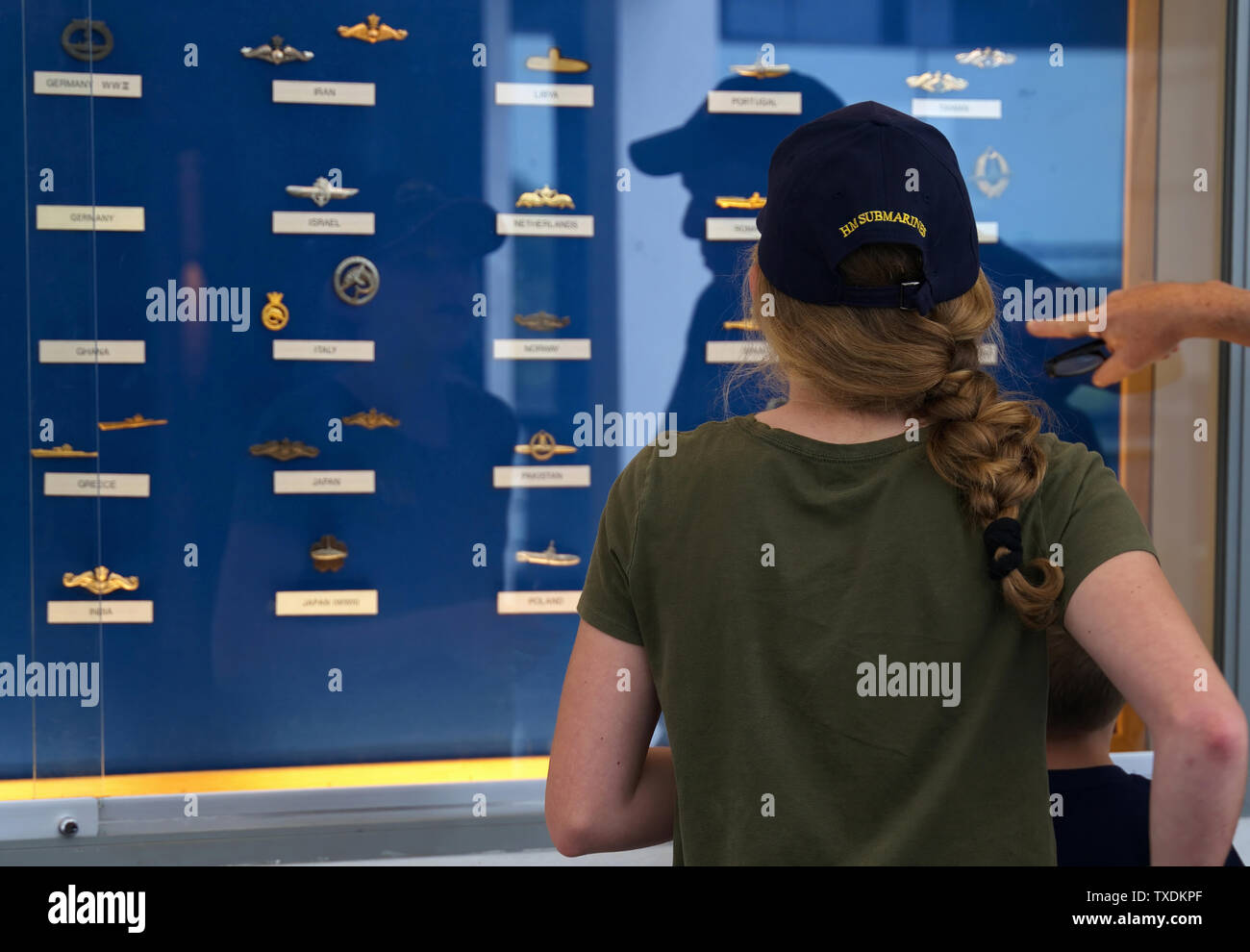 U-Boot Museum, Groton CT USA, Juni 2019. Grandkids verschiedene U-Boot Abzeichen aus anderen Ländern mit Großvater. Stockfoto