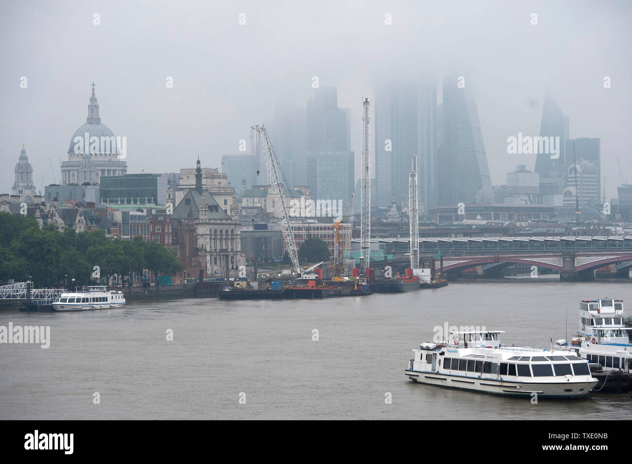 Grauer Himmel über die Skyline von London. Gewitter durch eine Feder des warmen kontinentalen Luft angetrieben haben begonnen zu entladen' kräftige Regengüsse und Blitze über South East England. Stockfoto