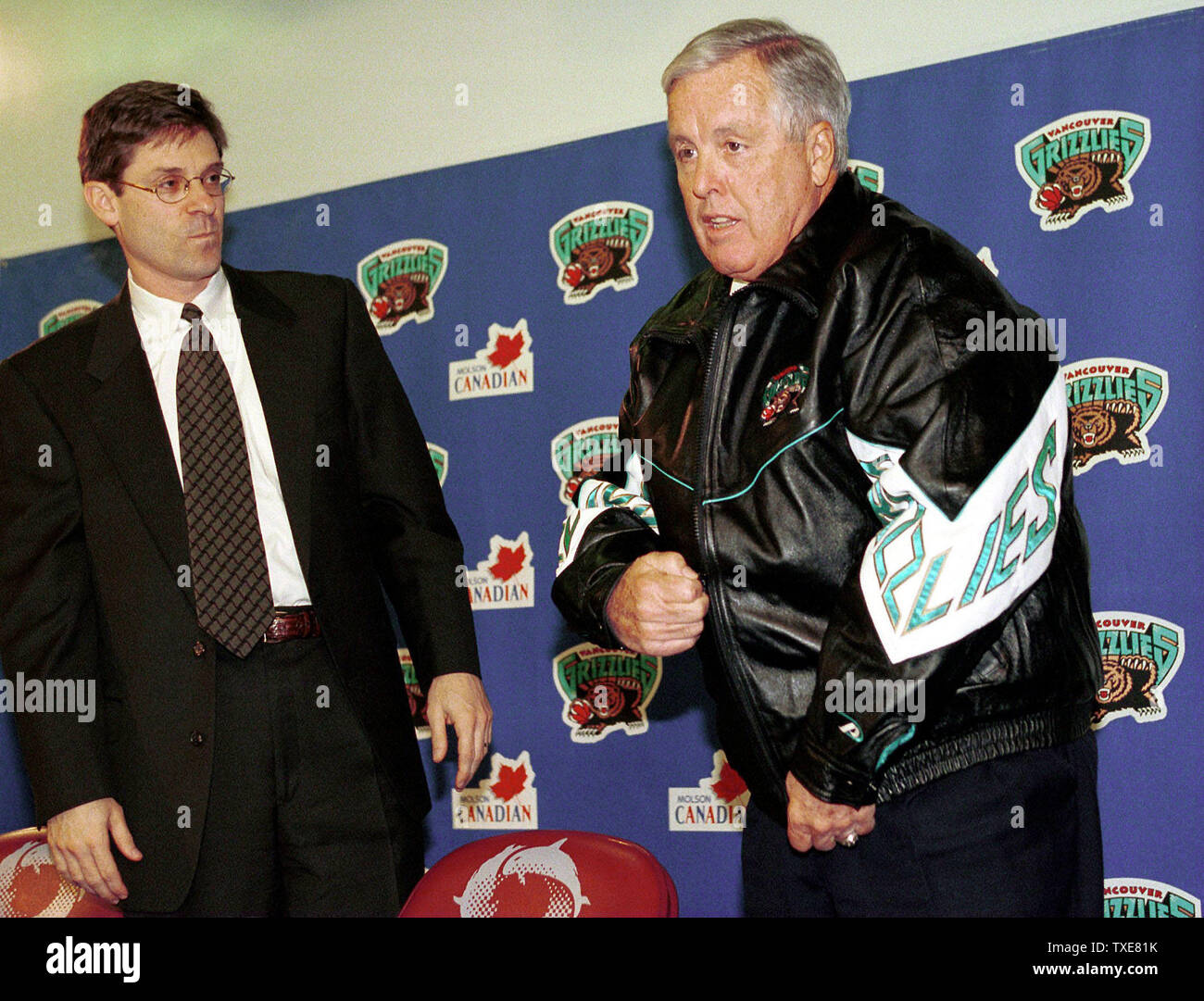 VAN 2000012403 - 24 Januar 2000 - VANCOUVER, BC, Kanada: Orca's Bay Stan McCammon als Chicago Milliardär Michael Heisley Reißverschluss ein Vancouver Grizzlies team Jacke an Vancouver, GM Place während einer Pressekonferenz über seinen Kauf der NBA Grizzlies, am 24. Januar. Diese zweite Kauf der Grizzlies innerhalb eines Jahres muss noch durch den Vorstand der NBA League der Gouverneure genehmigt werden. rg/hr/H. Ruckemann UPI Stockfoto