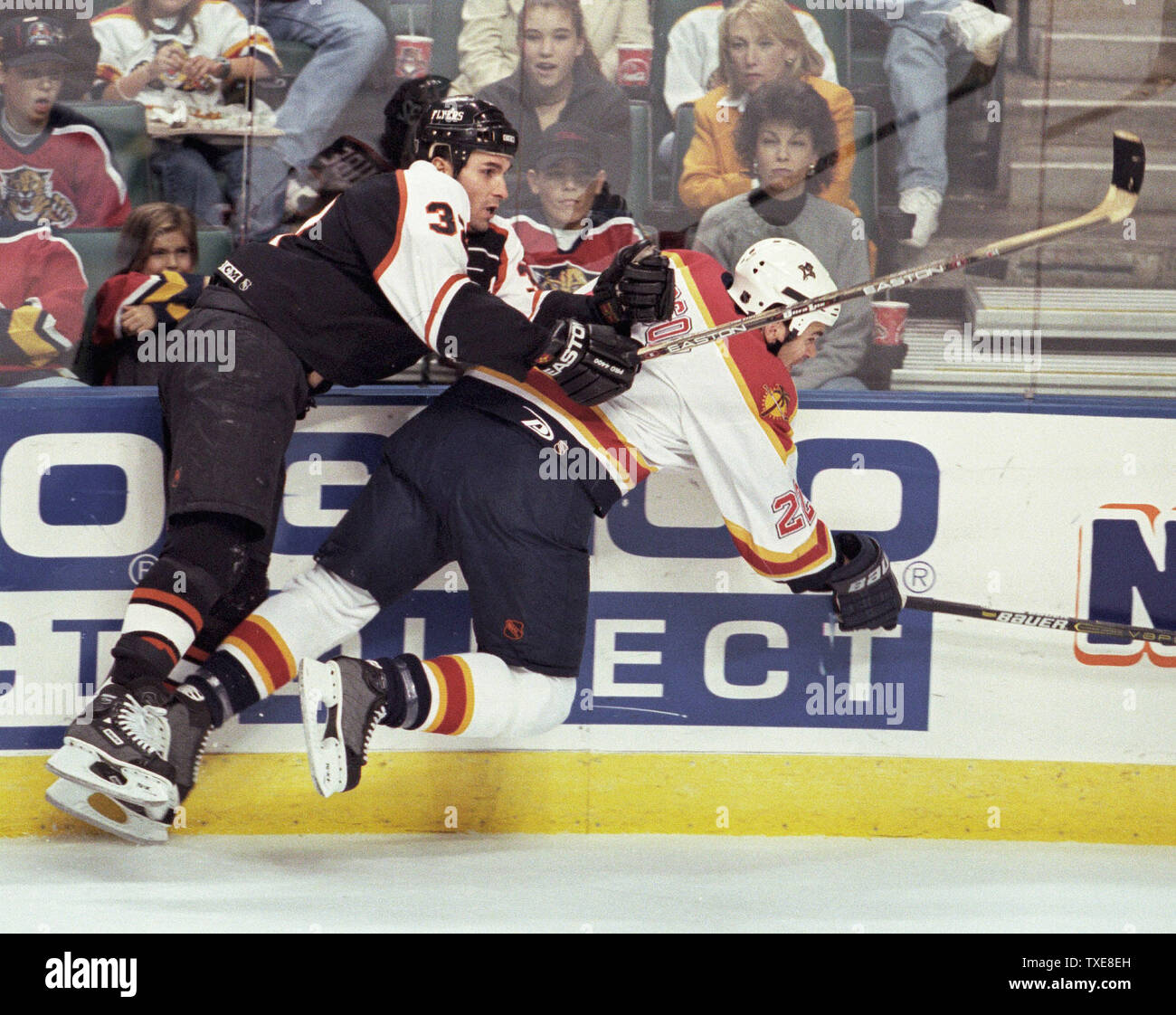 MIA 2000011702 - 17 Januar 2000 - Miami, Florida, USA: Philadelphia Flyers Craig Berube (32) klopft Florida Panthers Todd Simpson (22) von den Füßen in der ersten Periode NHL Tätigkeit, Januar 17. Die Leoparden besiegten die Flyer 3-1 in der National Car Rental Center. rg/mb/Michael Bush UPI Stockfoto