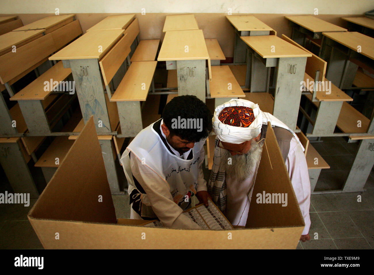 Ein afghanischer Abstimmungarbeiter (L) hilft dem Wähler im Wahllokal in Kabul, Afghanistan am 20. August 2009. Afghanen Abstimmung einen neuen Präsidenten für das zweite mal in der Geschichte des Landes zu wählen. UPI/Mohammad Kheirkhah Stockfoto