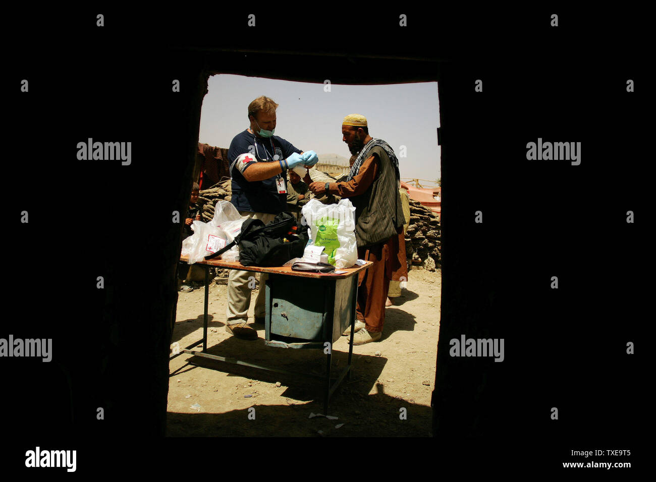 Amerikanische Gerald Scott Feuerstein (L), ein Sanitäter der Freiwilligen Sanitäter Weltweit (VMW) humanitäre Hilfe team, Schecks Hände eines Jungen in einer intern Vertriebenen (IDPs) Camp in Kabul, Afghanistan am 28. August 2009. UPI/Mohammad Kheirkhah Stockfoto