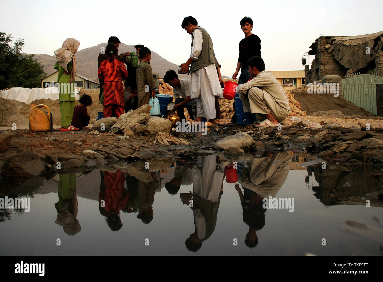 Reflexionen der Afghanis sind im Wasser gesehen, während sie Wasser in ihren Behältern in Kabul, Afghanistan am 30. August 2009. UPI/Mohammad Kheirkhah Stockfoto