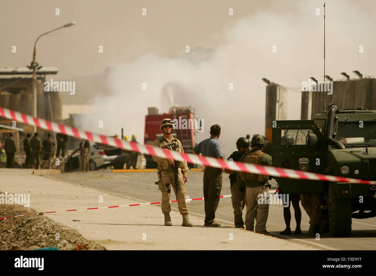 Rettungskräfte, die Flamme als NATO-Soldaten Wache an der Szene eines Selbstmordanschlag in Kabul, Afghanistan am 8. September 2009. Eine Autobombe in der Nähe der Eingang zur militärischen Kabul Airport in einem offensichtlichen Angriff auf eine internationale Konvoi explodierte, mindestens zwei Zivilisten getötet und verletzt sechs, Afghanische Beamte sagte. Die Taliban behauptete Verantwortung für die Hochöfen. UPI/Mohammad Kheirkhah Stockfoto