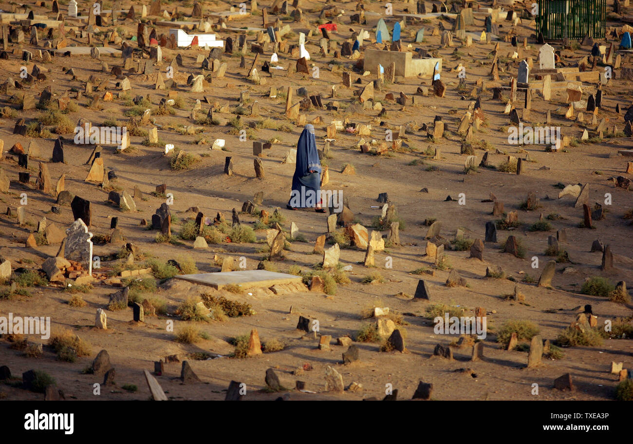 Eine Burka bekleideten Frau geht unter die Gräber auf dem Friedhof am letzten Tag der Eid Al-Fitr, den Feiertag markiert das Ende der muslimischen heiligen Fastenmonats Ramadan, in Kabul, Afghanistan am 22. September 2009. UPI/Mohammad Kheirkhah Stockfoto