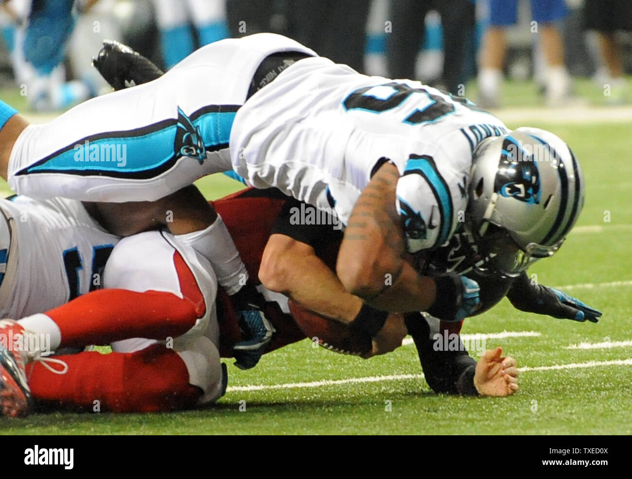 Atlanta Falcons quarterback Matt Ryan (2) Ist nach der Carolina Panthers defensive Ende Greg Hardy geholt (76) auf der dritten und - neun in der ersten Hälfte im Georgia Dome in Atlanta am 29. Dezember 2013. UPI/David Tulis Stockfoto