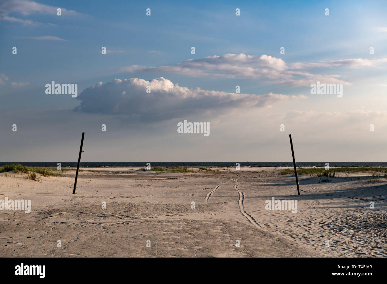 Mystic Pfad über Sand Feld durch zwei Säulen zu Strand mit dramatischen Cloud. Stockfoto