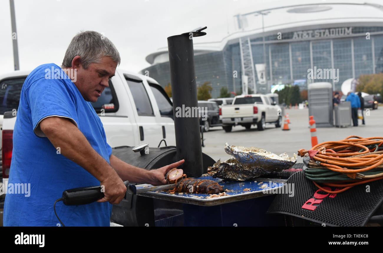 Pete Holmes schnitzt Schweinefilet für seine Thanksgiving Mahlzeit während tailgating vor der Dallas Cowboys und Carollna Leoparden Spiel bei AT&T Stadium am 26. November 2015 in Arlington, Texas. Foto von Ian Halperin/UPI Stockfoto