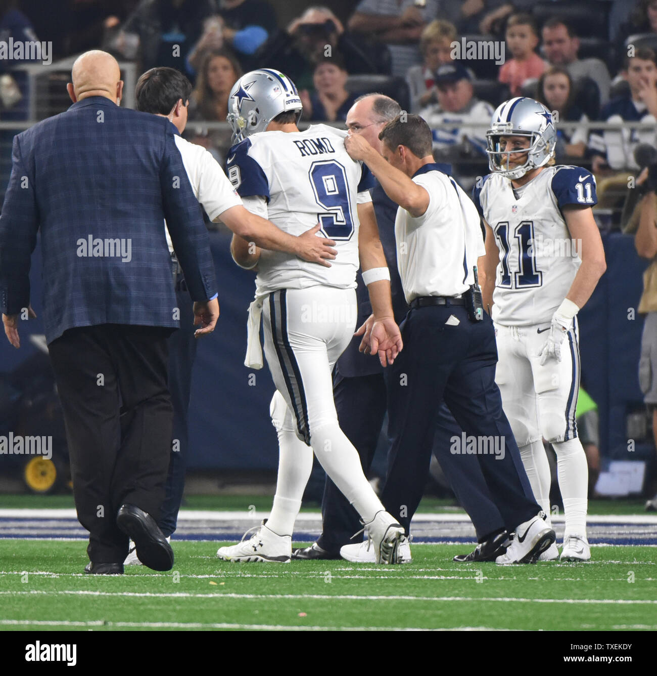 Dallas Cowboys Quarterback Tony Romo ist aus dem Feld geholfen, nachdem sie seine Schulter zum Ende des dritten Viertel gegen Carolina Panthersat AT&T Stadium am 26. November 2015 in Arlington, Texas. Die Leoparden besiegten die Cowboys 33-14 und 11-0 bewegen. Foto von Ian Halperin/UPI Stockfoto