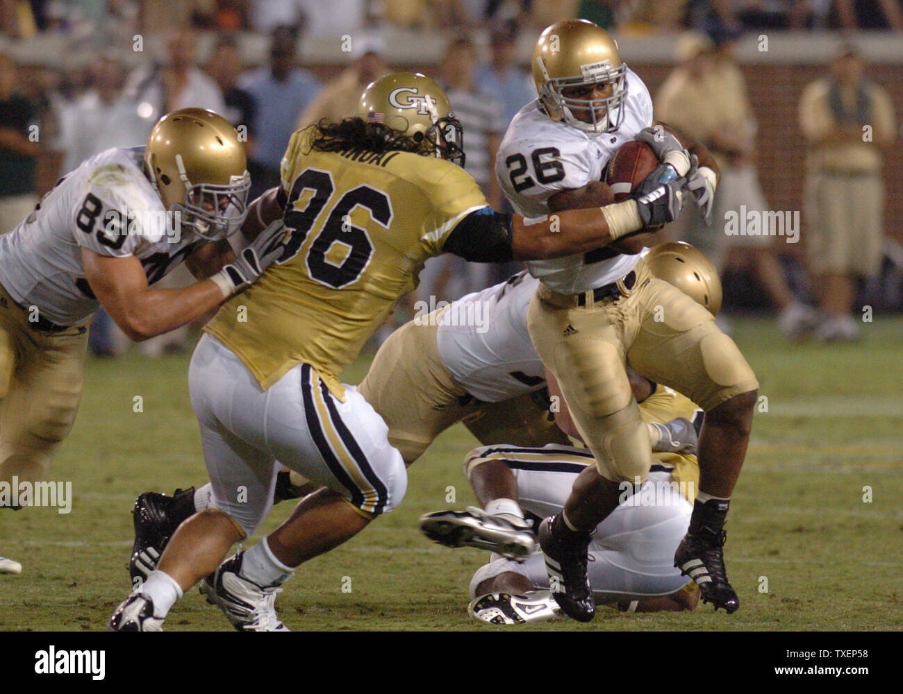 Notre Dame zurück laufen Travis Thomass (26) läuft zunächst yardage im vierten Quartal durch die Verteidigung der Georgia Tech defensiver Joe Anoai (96) im Bobby Dodd Stadium in Atlanta, Ga., 2. September 2006. Notre Dame ist John Carlson hilft. Notre Dame besiegte Georgia Tech 14-10. (UPI Foto/Peter Stöger) Stockfoto