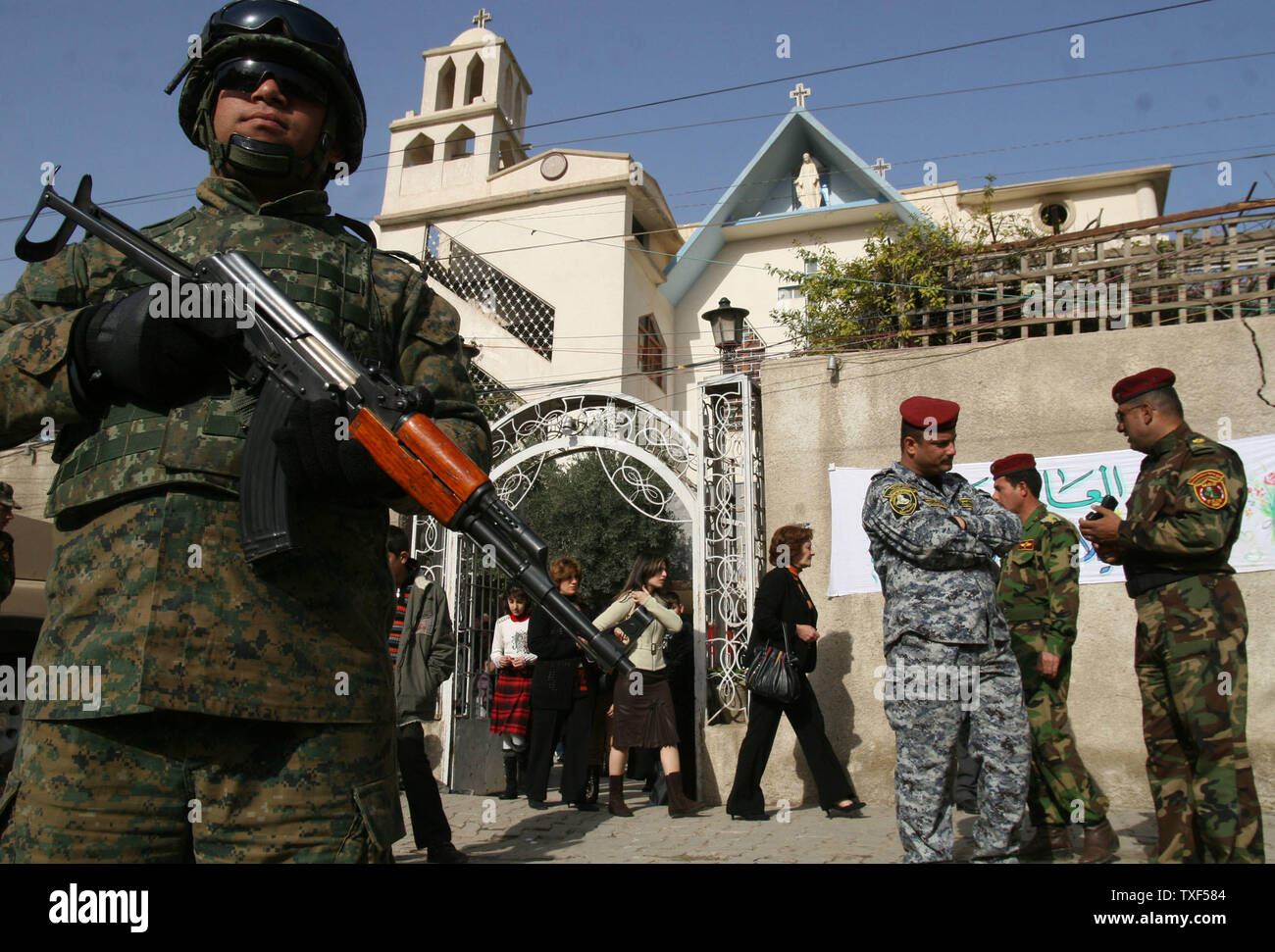 Irakische Polizisten stand Guard außerhalb der Jungfrau Maria Kirche, als Anbeter nach Weihnachten Masse in Bagdad, Irak am 25. Dezember 2008 verlassen. Weihnachten war ein offizieller Feiertag im Irak zum ersten Mal in diesem Jahr erklärt. (UPI Foto/Ali Jasim) Stockfoto