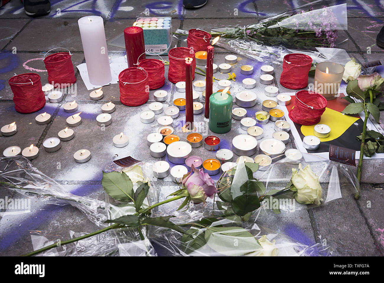 Ein Bild zeigt layed Kerzen und Rosen, wie die Leute, um eine Schweigeminute im Gedenken an die Opfer des Brüsseler Flughafen und Metro Bombardierungen zu beobachten, auf der Place de la Bourse im Zentrum von Brüssel, am 23. März 2016, einen Tag nach dem Dreifachen blasts etwa 30 Menschen getötet und etwa 250 verletzt worden. Die Staats- und Regierungschefs vereinigten in der Verurteilung des Massakers in Brüssel und schwor, den Terrorismus zu bekämpfen, die nach islamischen Staat Bomber rund 35 Menschen in einem Streik an der symbolischen Herzen der EU. Foto von Diego Ravierl/UPI getötet Stockfoto