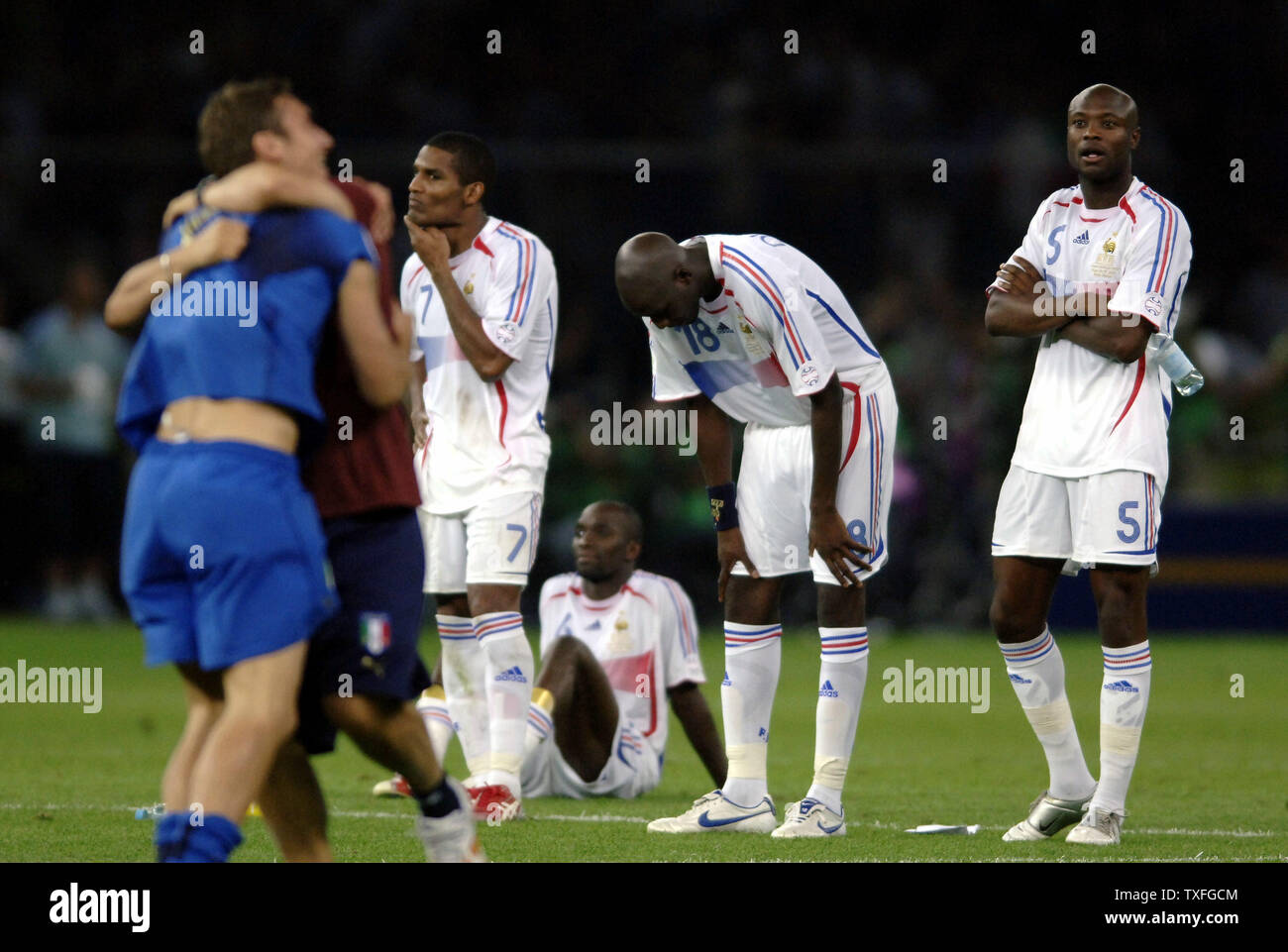 Frustriert die französischen Spieler Alou DIARRA (18), William Gallas (5) und Florent Malouda (7) die Freude über die ausgezeichneten italienischen Spieler nach dem verlorenen WM-Finale nach Italien in Berlin beobachten, Deutschland am Sonntag, den 9. Juli 2006. Italien Weltmeister nach einem Penalty Shoot Out umrandete Frankreich 5-3. (UPI Foto/Thierry Gromik) Stockfoto