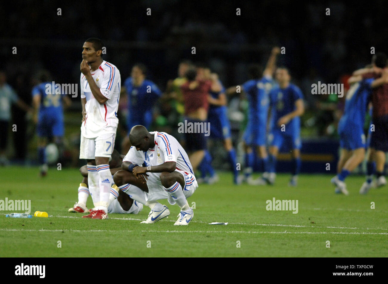 Frustriert die französischen Spieler Alou DIARRA (18), William Gallas (5) und Florent Malouda (7) die Freude über die ausgezeichneten italienischen Spieler nach dem verlorenen WM-Finale nach Italien in Berlin beobachten, Deutschland am Sonntag, den 9. Juli 2006. Italien Weltmeister nach einem Penalty Shoot Out umrandete Frankreich 5-3. (UPI Foto/Thierry Gromik) Stockfoto