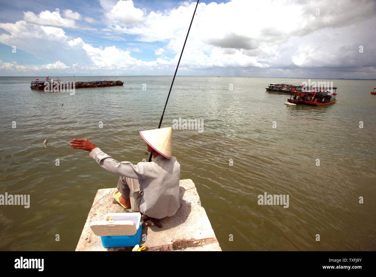 Ein chinesischer Mann Fische in Beihai, einer Küstenstadt im Süden der Provinz Guangxi, China am 5. September 2014. Obwohl China rasch seine Wirtschaft durch internationalen Handel gestärkt hat, es ist noch immer ein Entwicklungsland aufgrund der Tatsache, dass die Mehrheit der Chinesen haben einen niedrigeren Lebensstandard als die entwickelten Länder. UPI/Stephen Rasierer Stockfoto