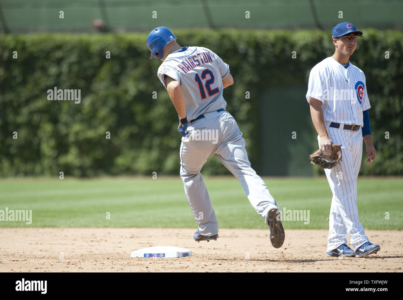 New York Mets" Scott Hairston (L) runden die Grundlagen wie Chicago Cubs zweiter Basisspieler Darwin Barney auf dem Feld steht nach Hairston ein Grand Slam hit zählenden Ruben Tejada, David Wright und Lucas Duda verlassen das Baseballstadion im sechsten Inning am Wrigley Feld am Juni 27, 2012 in Chicago. UPI/Brian Kersey Stockfoto