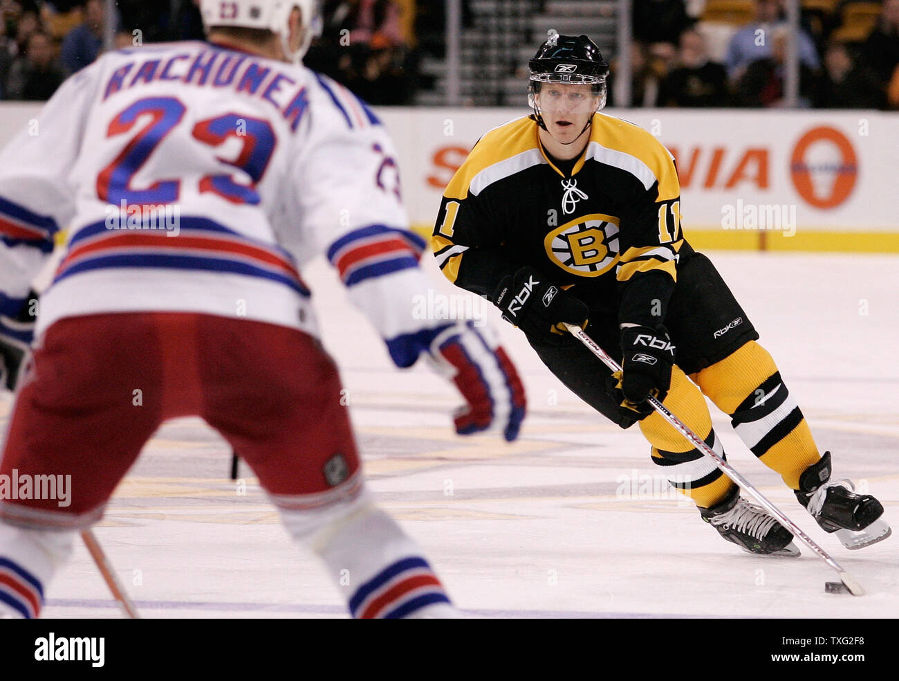 Boston Bruins weiter P.J. Axlson (11) von Schweden nach oben Eis in Richtung New York Rangers defender Karel Rachunek (23) der Tschechischen Republik in der zweiten Periode am 29. Januar 2007 Im TD Banknorth Garden in Boston. (UPI Foto/Matthew Healey) Stockfoto