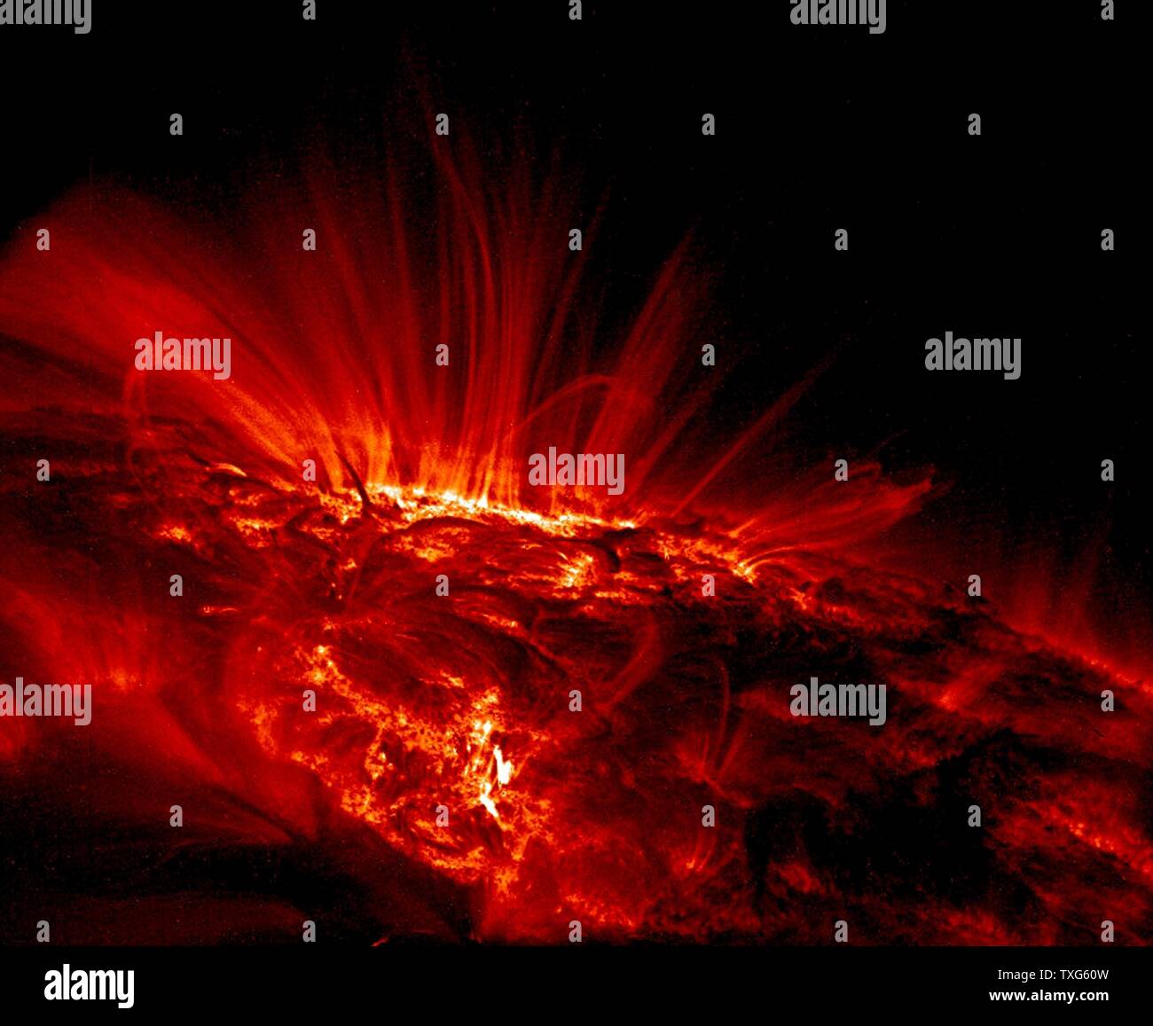 UV-Bild zeigt helle, leuchtende Bögen von Gas fließt um die Sonnenflecken Stockfoto